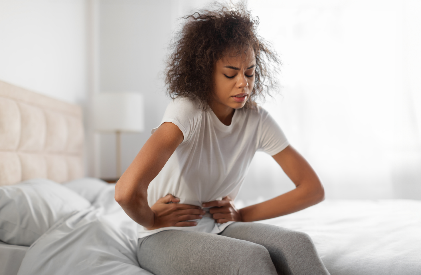 Mulher jovem sentindo desconforto das dores femininas